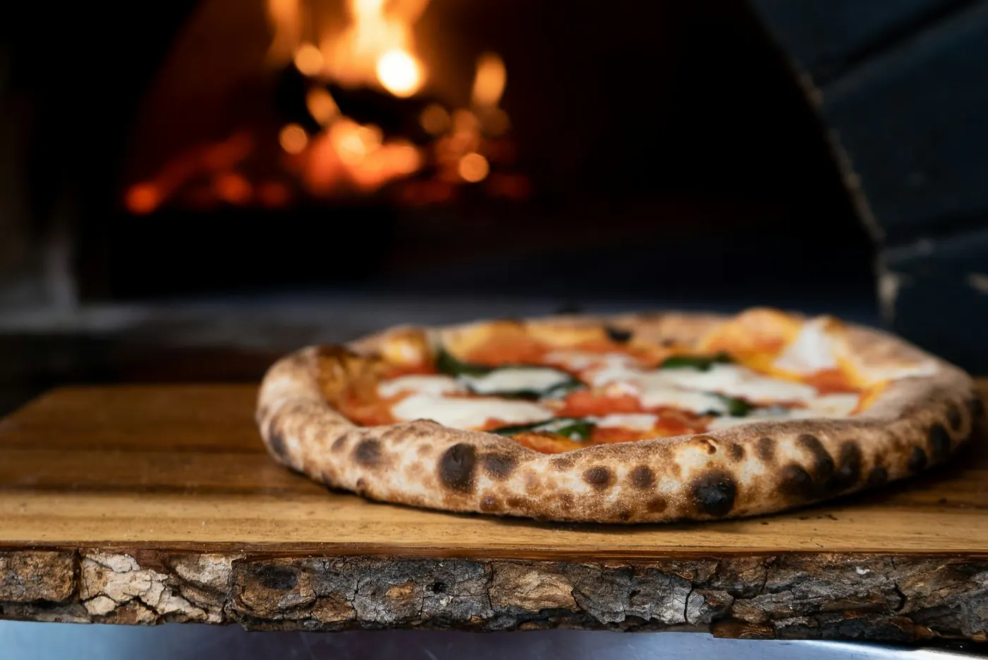 Pizza saliendo del horno de leña